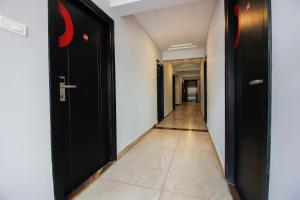 a hallway with black doors and a tile floor at Townhouse Halcyon Hi-Tech City Near Medicover Hospital in Kondapur