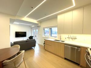 a kitchen and living room with a couch and a table at Modern Apartment Close To The Beach with Parking in Toronto