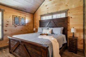 a bedroom with a bed in a wooden cabin at Dog Friendly New Cabin w/ Hot Tub, Game Room & 4-m in Sevierville