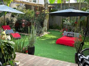 a garden with a red bed and an umbrella at UFSC Guest House in Florianópolis