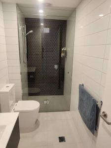 a bathroom with a toilet and a glass shower at Modern Apartment Airport Area in Melbourne