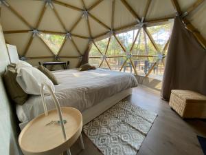 a room with a bed and a table in a yurt at Dome - Colares, near the center of Sintra in Colares