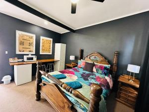 1 dormitorio con 1 cama con marco de madera en Flinders Ranges Motel - The Mill, en Quorn