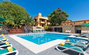 a swimming pool with lounge chairs and umbrellas at Hotel Rural Finca Salamanca in Güimar