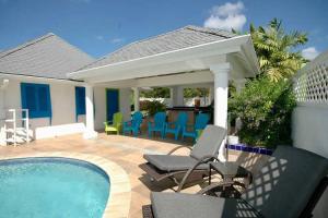un patio con sillas y una piscina en The Heart Villa, Exquisite Pool to Relax & Unwind en Golden Grove