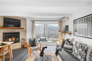 Una sala de estar con un sofá y una chimenea. en Charming Condo With Views Of Mont-tremblant, en Mont-Tremblant