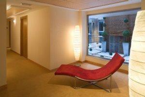 a red chair in a room with a window at Hotel Arena in Gijón