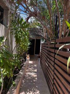 a wooden fence with plants and a walk way at Garden Suite 1 Estación 48 in Mérida