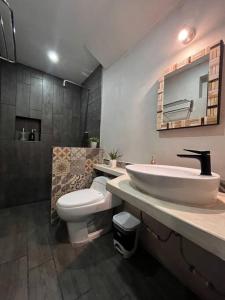 a bathroom with a sink and a toilet and a mirror at Garden Suite 1 Estación 48 in Mérida