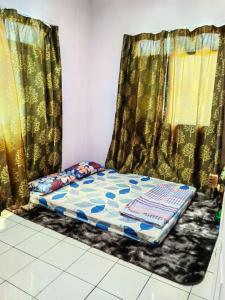 a bed sitting in a room with curtains at SJ Homestay & Room Rental. in Kota Belud