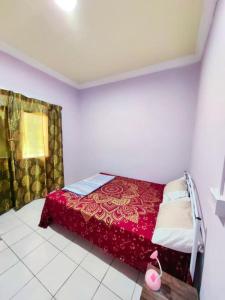 um quarto com uma cama vermelha num quarto em SJ Homestay & Room Rental. em Kota Belud