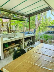 une terrasse avec deux tables et un comptoir avec un évier dans l'établissement SJ Homestay & Room Rental., à Kota Belud