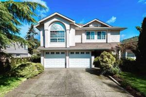 a large white house with a garage at Monthly Furnished Bright Beautiful 3bedroom Suite in Victoria