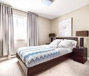 a bedroom with a large bed and a window at Monthly Furnished Bright Beautiful 3bedroom Suite in Victoria