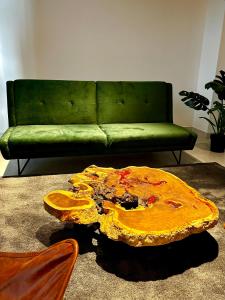 a living room with a green couch and a table at INTO suites, suite de lujo in Armenia
