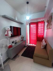 een woonkamer met een bank en rode gordijnen bij Staycation Near MOA by Cozypura with Pay Parking at S Res MOA in Manilla