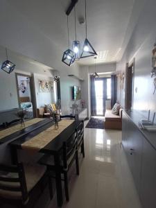 een keuken en een woonkamer met een tafel en stoelen bij Staycation Near MOA by Cozypura with Pay Parking at S Res MOA in Manilla
