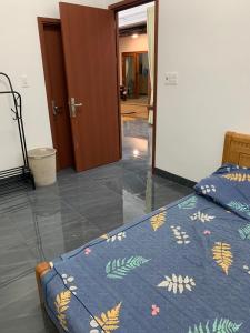 Schlafzimmer mit einem Bett mit blauer Decke in der Unterkunft Pin's House in Xã Tân Phát