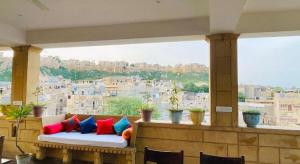 a couch sitting in front of a large window at Desert Golden Palace in Jaisalmer