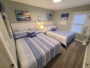 - une chambre avec 2 lits avec des draps bleus et blancs dans l'établissement The Cottage At Long Lake, à Portage