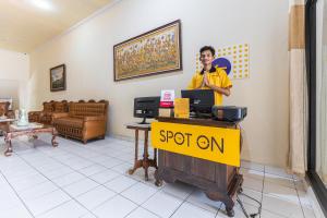 a man talking on a cell phone in a store at SPOT ON 1990 Pondok Ripuji in Makassar