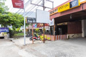 a street sign in front of a building with motorcycles at SPOT ON 1990 Pondok Ripuji in Makassar