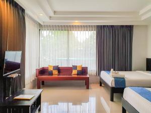 Habitación de hotel con sofá y ventana en Phornpailin Riverside Resort, en Sangkhla Buri