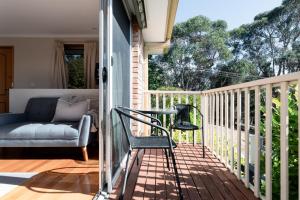 a balcony with a couch and a table and chairs at Beautiful Sunny Home: Close to the CBD & Gorge in Royal Park