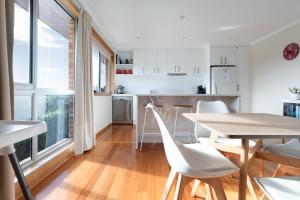 een keuken en eetkamer met een tafel en stoelen bij Beautiful Sunny Home: Close to the CBD & Gorge in Royal Park