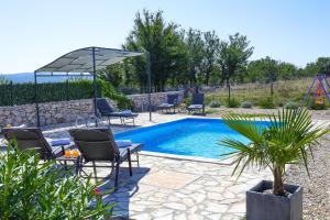 una piscina in un cortile con sedie e ombrellone di Villa Niko Your vacation starts here a Rudine