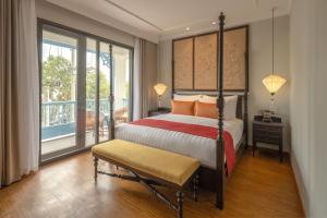 ホイアンにあるLittle Residence- A Boutique Hotel & Spaのベッドとバルコニー付きのホテルルーム
