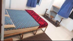 a couch with a red blanket on top of it at Funk monk Villa hostel PONDICHERRY in Auroville
