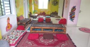 オーロヴィルにあるFunk monk Villa hostel PONDICHERRYのリビングルーム(ソファ、赤い椅子付)