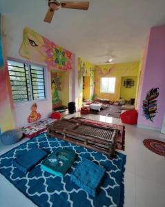 黎明之村Funk monk hostel PONDICHERRY的卧室配有一张床,卧室的墙壁上装饰有绘画作品