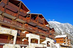 a building with balconies and a mountain in the background at Résidence Le Chardonnet - Studio pour 4 Personnes 193282 in Champagny-en-Vanoise