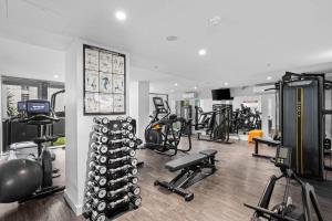 a gym with a lot of treadmills and machines at Cosy 1-Bed Unit with a Gym, BBQ Area, Spa and Pool in Brisbane