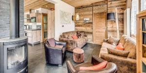 a living room with a fireplace in a log house at Chalet Les Lauzes - Chalets pour 10 Personnes MAE-3288 in Champagny-en-Vanoise
