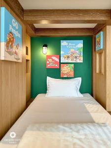 a bed in a room with a green wall at Discovery Hotel in Magong