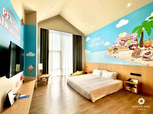 a bedroom with a bed and a wall with a mural at Discovery Hotel in Magong