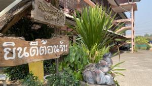 Une statue d'un éléphant assis à côté d'un panneau dans l'établissement Thaen Thong Hotel, à Lamphun