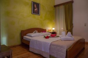 a bedroom with two beds with white sheets and flowers at Philoxenia Apartments in Kryonéri