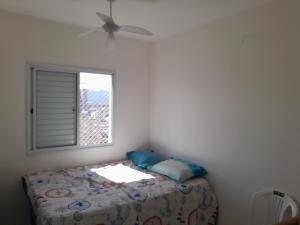a small bedroom with a bed and a window at Eduardo Gimenes Palazzi in São Vicente