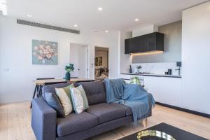 uma sala de estar com um sofá e uma cozinha em Modern 2br Apartment With Free Carpark And Pool em Melbourne