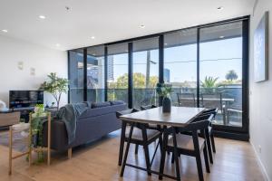 uma sala de estar com um sofá e uma mesa em Modern 2br Apartment With Free Carpark And Pool em Melbourne