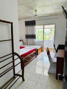 a bedroom with a bed and a chair in a room at Blue Lotus Garden Hotel piliyandala in Colombo