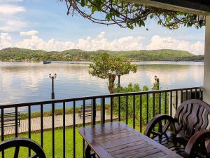 a table and chairs on a balcony with a view of a lake at Phornpailin Riverside Resort in Sangkhla Buri +162 photos