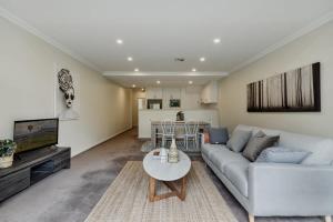 uma sala de estar com um sofá e uma mesa em Modern apartment in the heart of Canberra em Kingston 