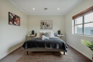 a bedroom with a bed and a large window at Modern apartment in the heart of Canberra in Kingston 