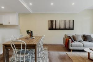 a living room with a table and a couch at Modern apartment in the heart of Canberra in Kingston 