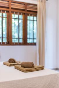 un par de toallas sentadas encima de una cama en MAKAI Surf House en Ahangama